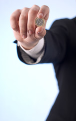 Dłoń trzymająca monetę jeden Euro