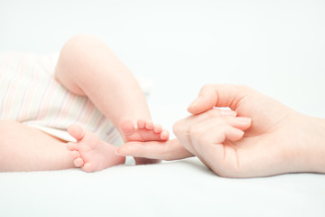 Fototapeta na wymiar little baby feet and hand of the mother