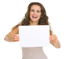Fototapeta premium Happy young woman showing blank paper