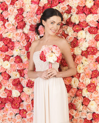 woman with bouquet and background full of roses