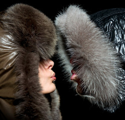Kiss in the winter of men and women in fur hoods