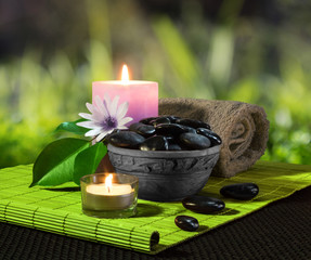 vaso di pietre nere e candele su stuoia verde