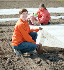 family warms the soil with polyethylene