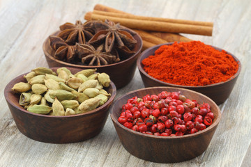 Mixed spices in miniature vintage bowls on wooden background