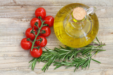 Cherry tomatoes, fresh rosemary and bottle of olive oil