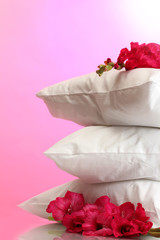 Fototapeta na wymiar poduszki i kwiaty na różowym tle