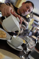 Man filling cup of tea