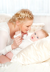 young mother with a baby in a beautiful bedroom