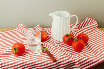 Fresh tomatoes on red striped tablecloth