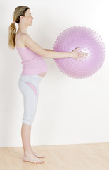 pregnant woman doing exercises with a ball