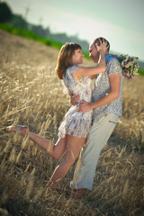 young couple embracing in a field of rye