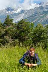 Naklejka na ściany i meble Woman with purple wild flowers (Alps, Switzerland)