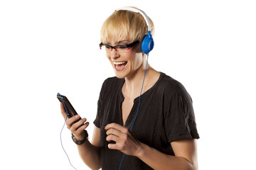 pretty blondewith  headphones, listening to music on her phone