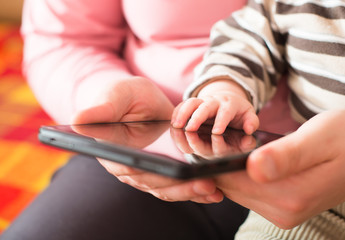 cheerful baby plays with  tablet PC