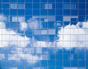 Clouds reflected in windows of modern office building