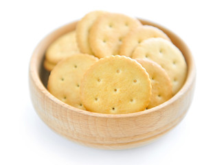 Crackers in a wooden bowl on white background