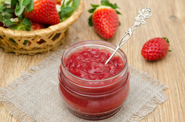 strawberry jam in a glass jar and fresh strawberries horizontal