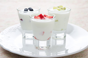 three yogurt with various fruits