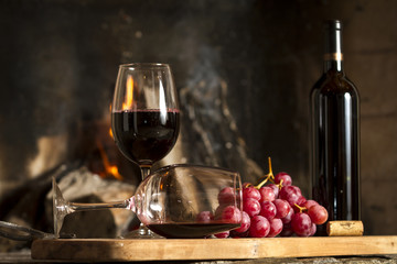 Copas de vino tinto, botella uvas y corcho.