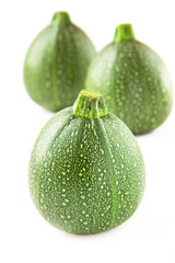 Isolated round courgette on white