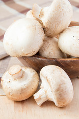 Champignons on table and in wooden bowl