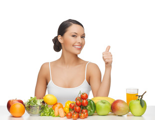 woman gives thumbs up with fruits and vegetables