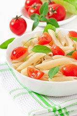 Pasta salad with cherry tomatoes and fresh basil leaves