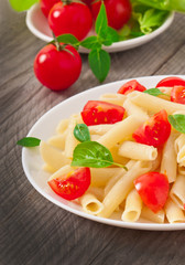 Pasta salad with cherry tomatoes and fresh basil leaves