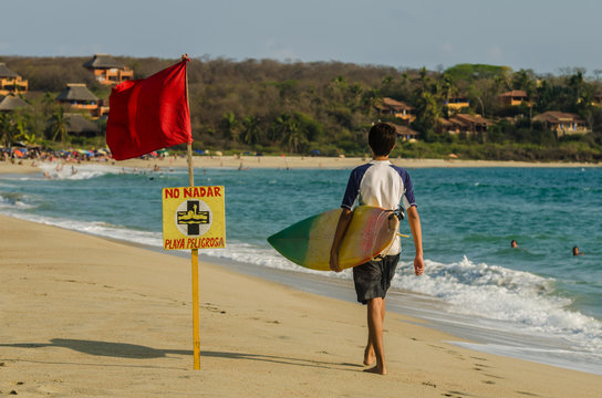 A surfer walking on the beach of Punta Zicatela, Oax
