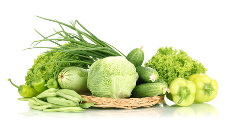 fresh green vegetables on wicker mat isolated on white