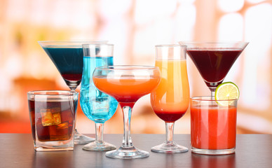 Several glasses of different drinks on bright background