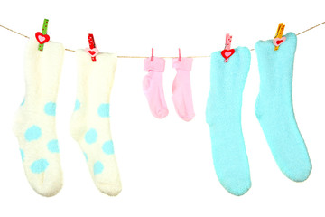 Colorful socks hanging on clothesline, isolated on white