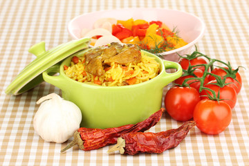 Delicious pilaf with vegetables on tablecloth background