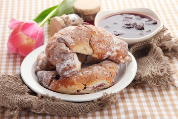 Taste croissants on plate and jam on tablecloth.