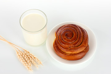 Bread roll and glass of milk isolated on white
