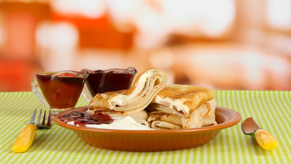 Pancakes with cottage cheese on plate on bright background