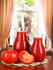 Tomato juice in pitchers on table in room