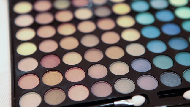 Make-up multicolor cosmetic palette on table. Camera rotation