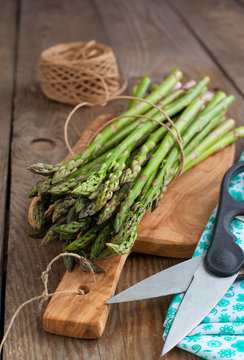 Fresh green asparagus sprouts on wooden table