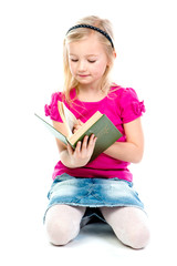Small and beautiful girl reading a book