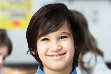 Happy smiling little boy in classroom