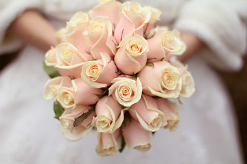 Wedding bouquet of roses in hands of the bride