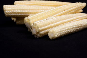 Baby corn on black background © bubu45
