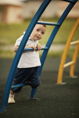 little boy plays on playground