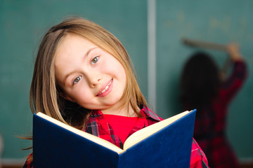 happy little schoolgirl portrait in classroom