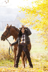 equestrian with her horse in autumnal nature