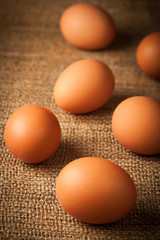 many hen eggs on burlap background