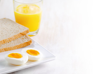 Fototapeta premium Boiled egg, toasts and orange juice.