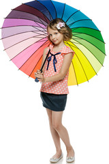 Little girl standing under colorful umbrella in full length