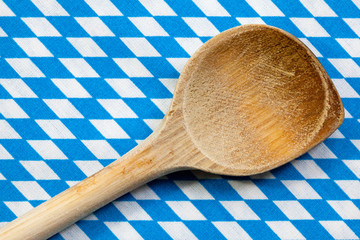 Antiker Kochlöffel aus Holz mit Hintergrund blau weiß